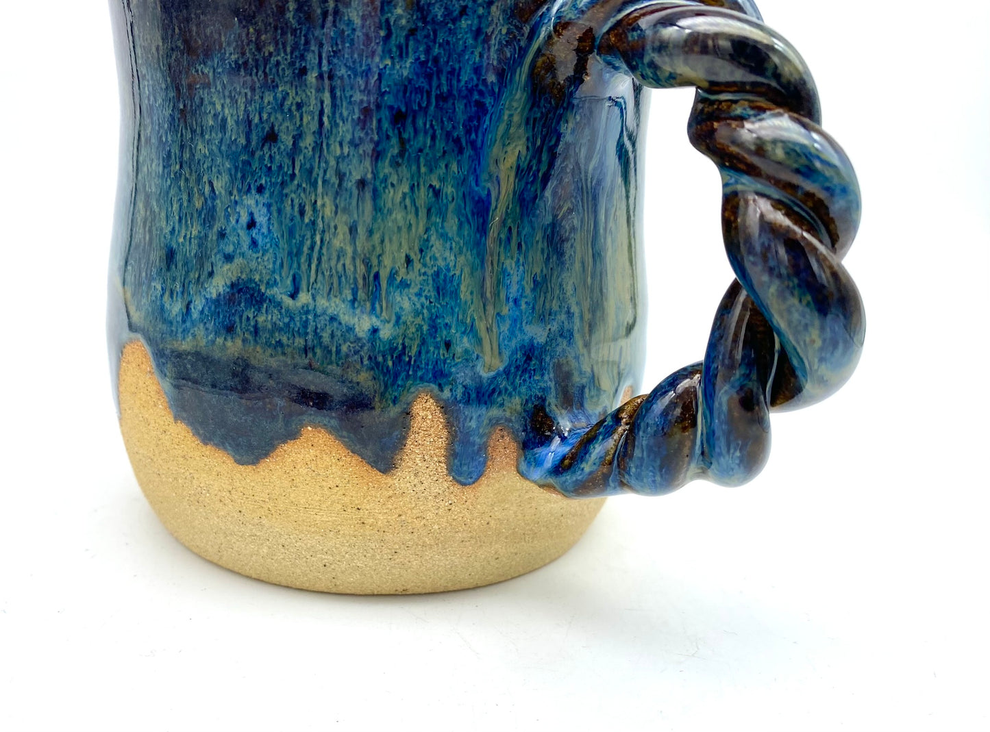 Mug in toasty clay with rich blue glazes