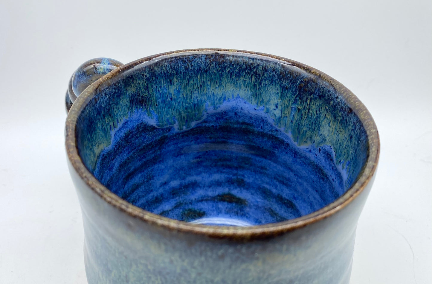 Mug in toasty clay with rich blue glazes