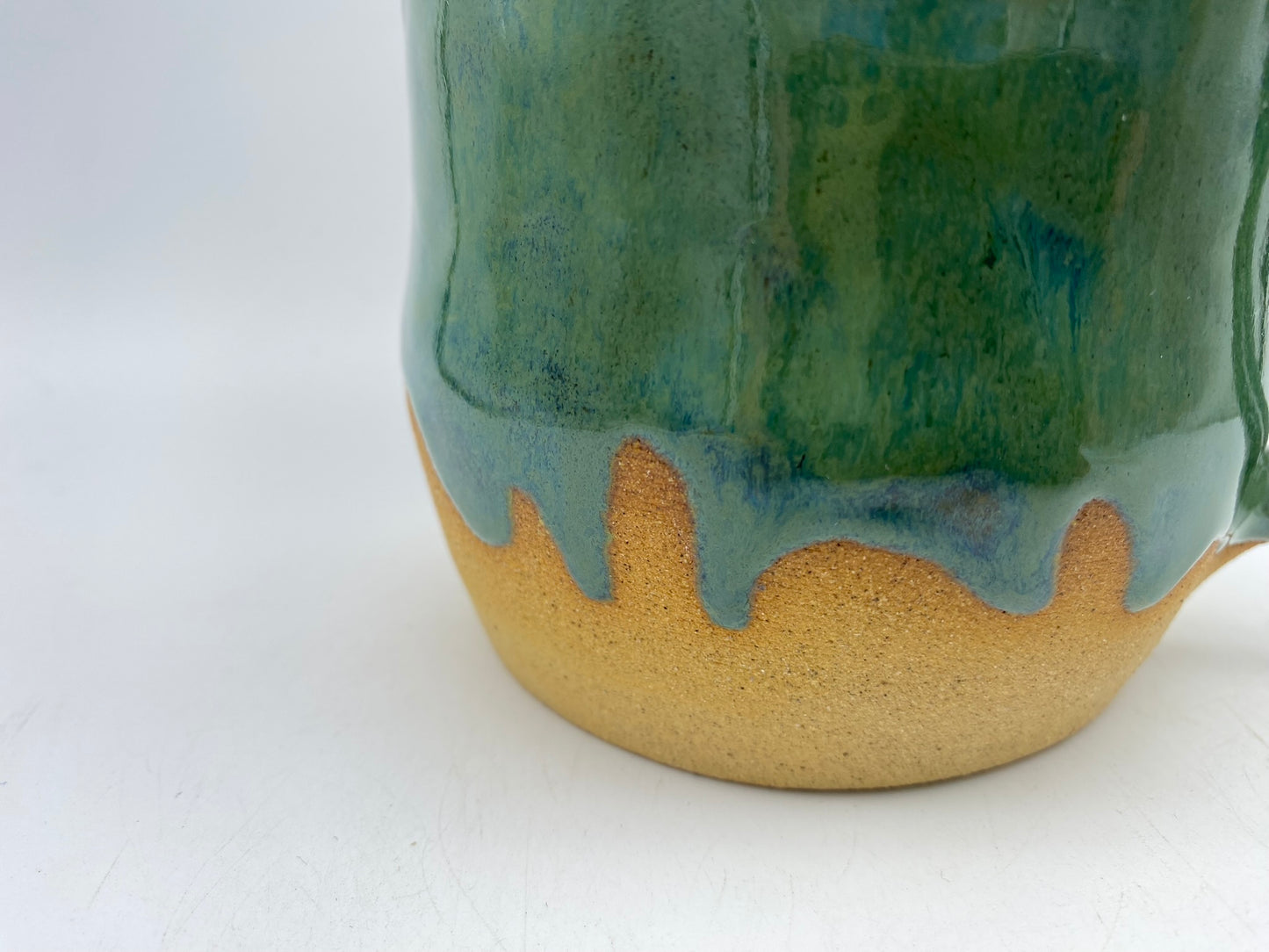 Mug in toasty clay glazed with flowing greens