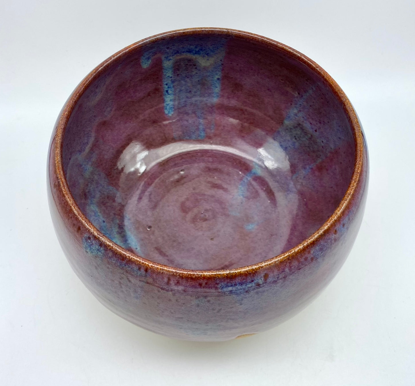 Larger bowl in toasty clay with purple glazes