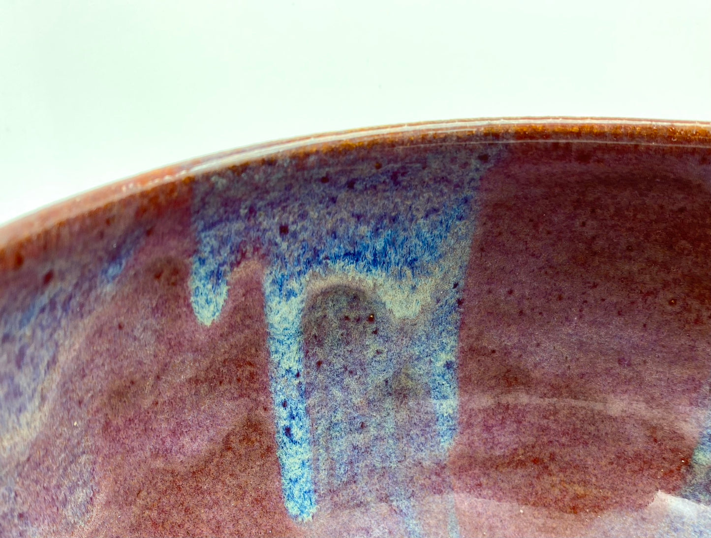 Larger bowl in toasty clay with purple glazes