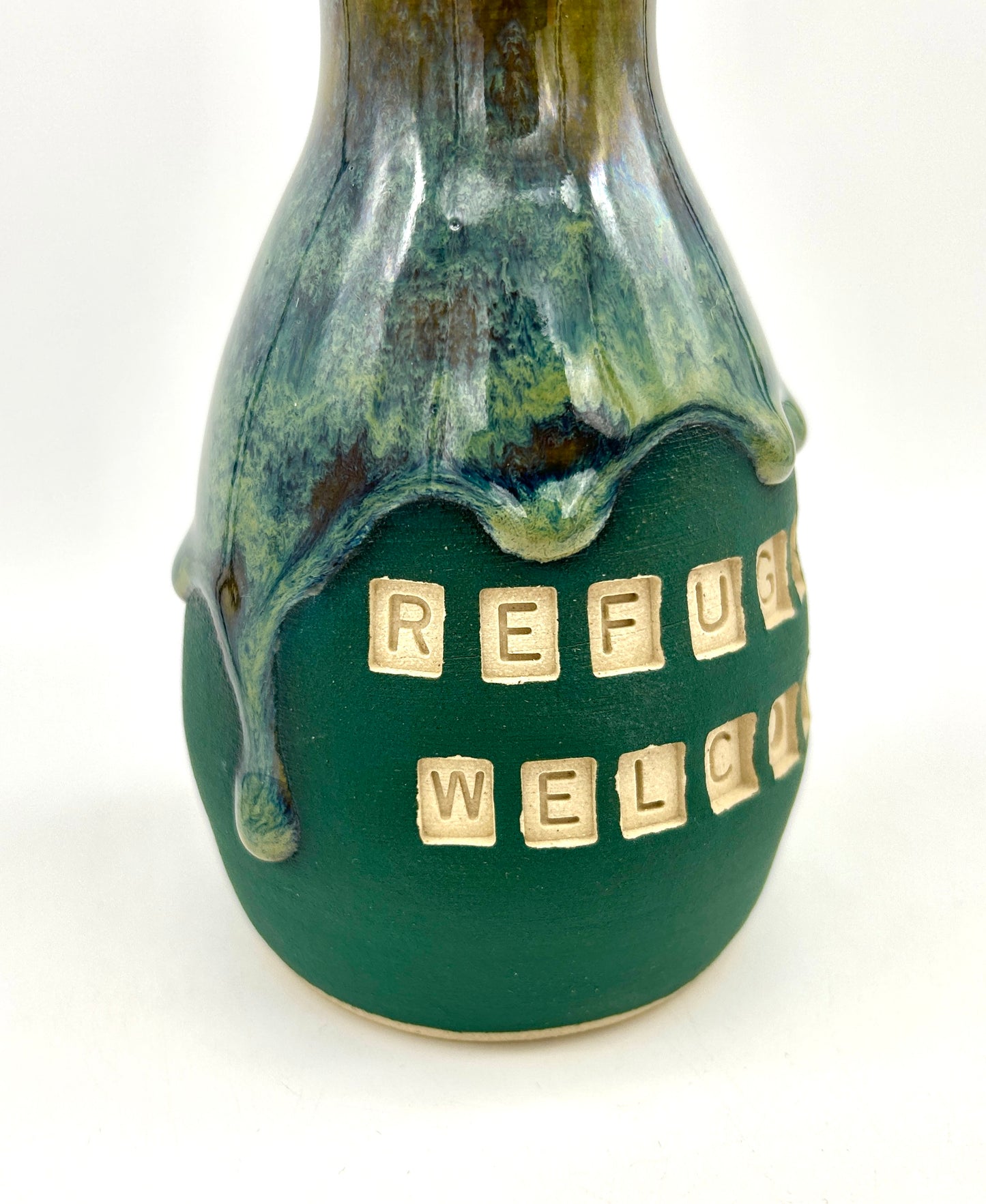 'Refugees welcome' vase in rich green flowing glazes