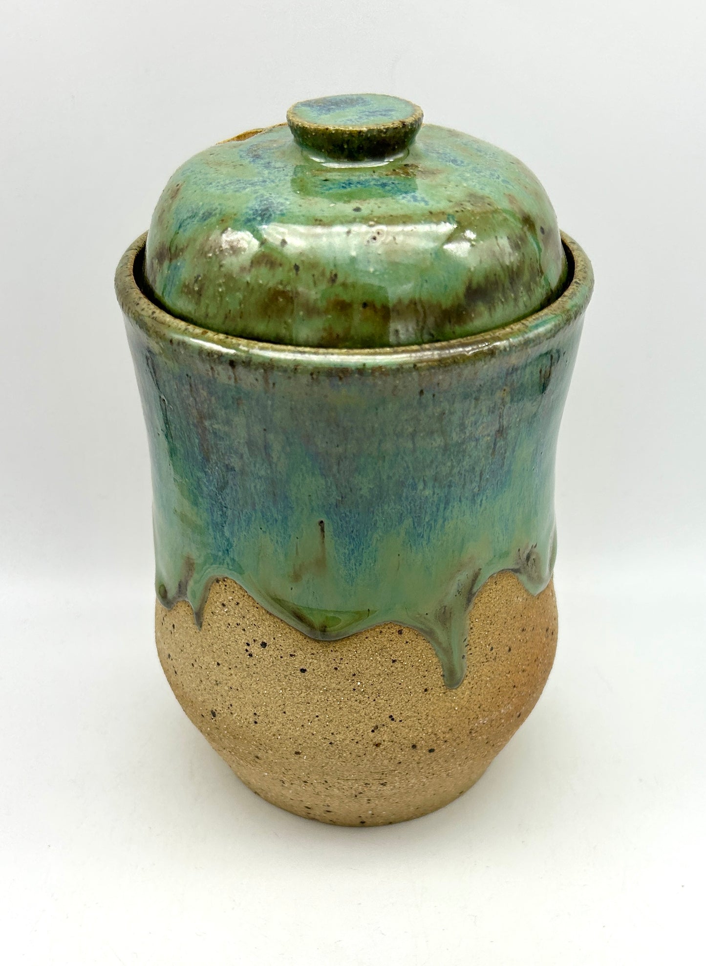 Tall 'drugs' jar in toasty clay glazed in flowing greens