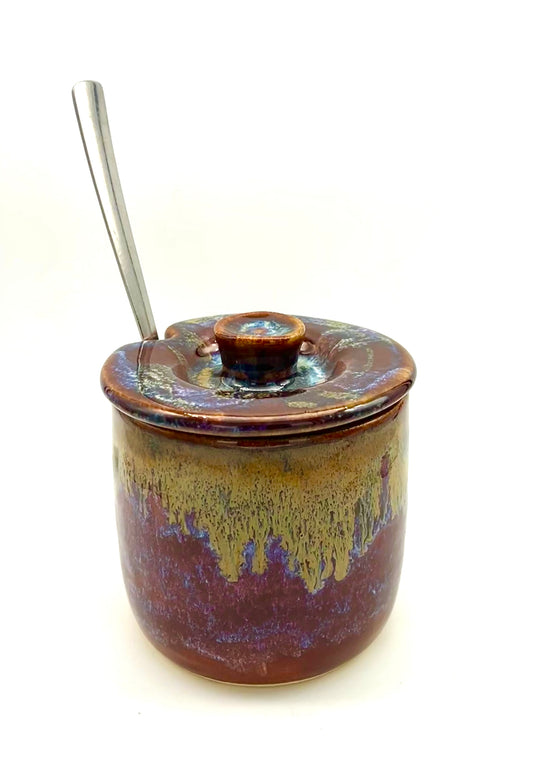 Lidded sugar jar with spoon notch in dark reds