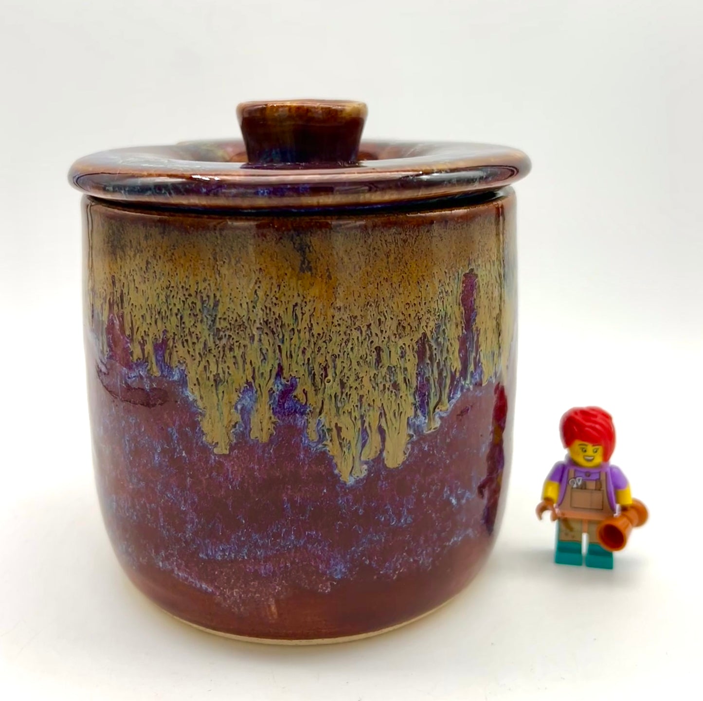 Lidded sugar jar with spoon notch in dark reds