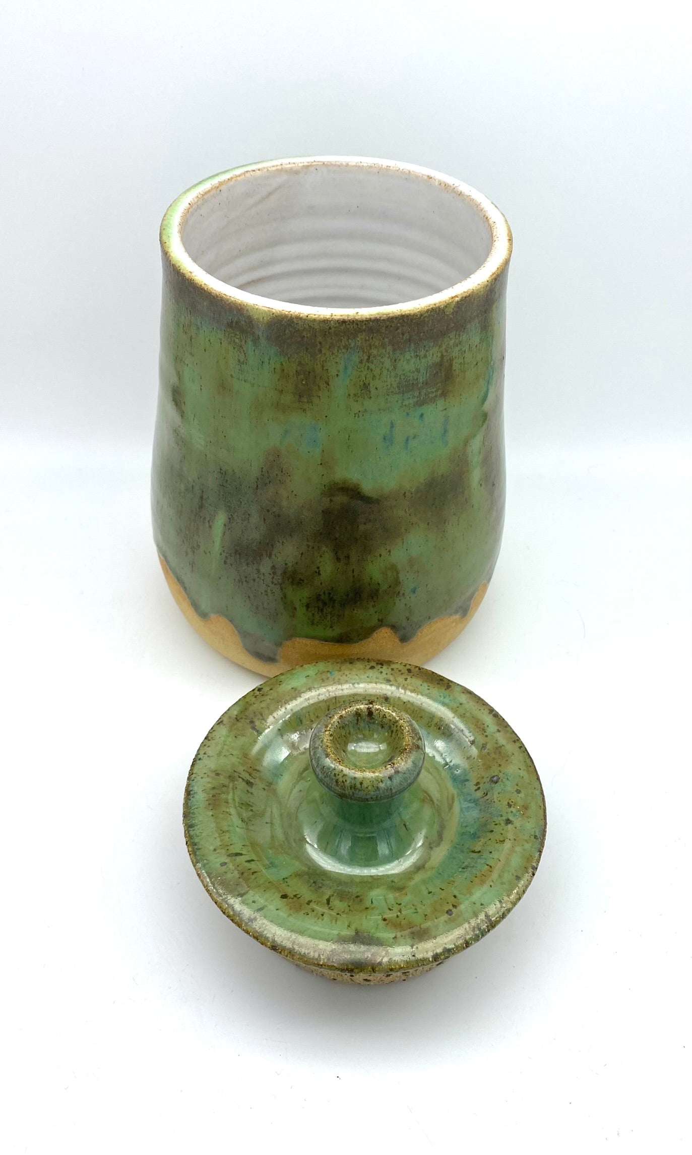 Lidded jar in greens on speckled clay