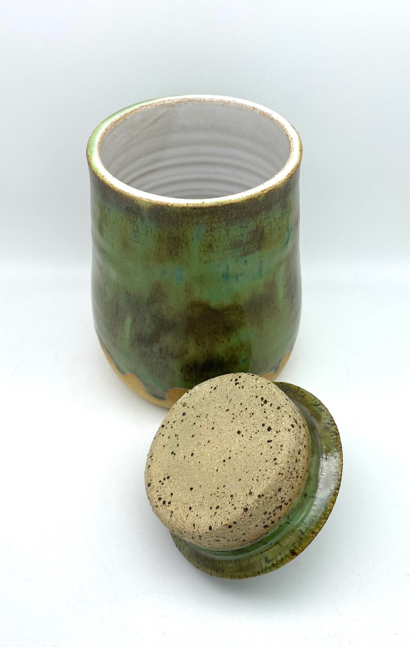 Lidded jar in greens on speckled clay